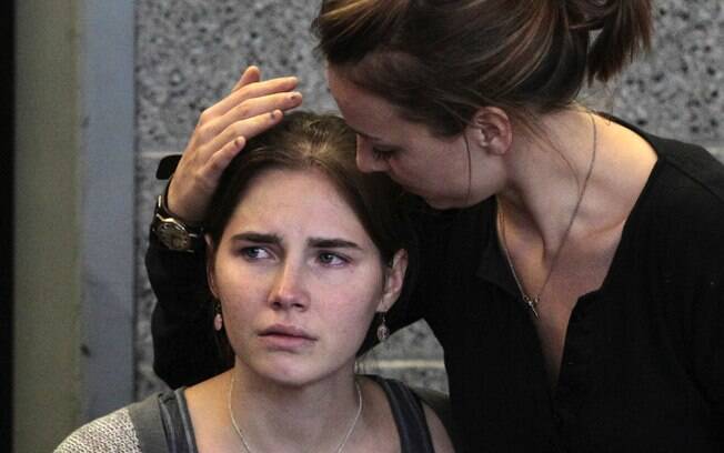 Amanda Knox (E) é consolada pela irmã, Deanna Knox, durante coletiva após sua chegada ao Aeroporto Internacional de Seattle, nos EUA