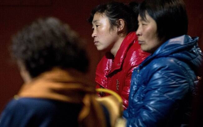 Parentes dos chineses a bordo do avião desaparecido da Malaysia Airlines aguardam notícias em sala de um hotel de Pequim, China (10/3). Foto: AP