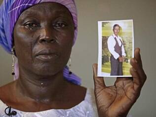 Martha Mark, mãe de Monica Mark%, uma das sequestradas em escola nigeriana chora ao mostrar foto da jovem na casa da família