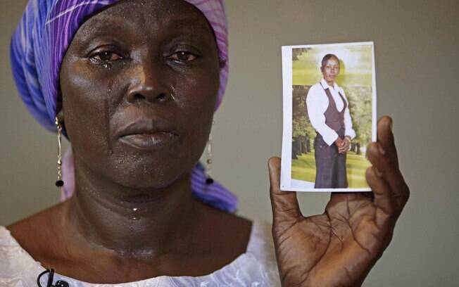 Martha Mark, mãe de Monica Mark, uma das sequestradas em escola nigeriana, chora ao mostrar foto da jovem na casa da família em Chibok, Nigéria (19/05). Foto: AP