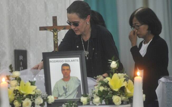 Angelita Muxfeldt, à esq., prima de Rodrigo Gularte, toca o caixão em casa funerária de Jacarta, Indonésia