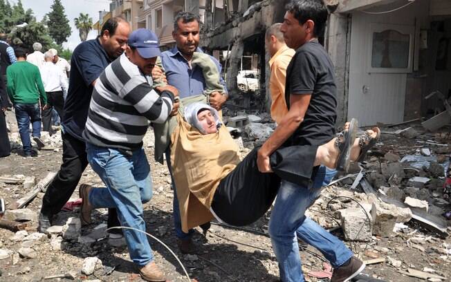 Homens carregam ferido após explosão em cidade turca perto da fronteira síria (11/05)
