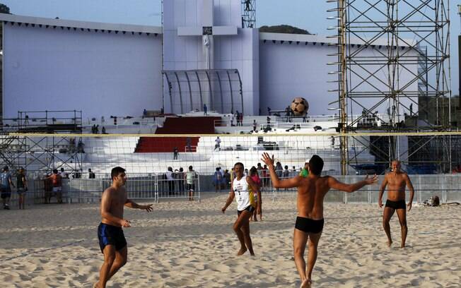 Jovens jogam futevôlei em frente ao palco em que o papa Francisco realizará missa em Copacabana  