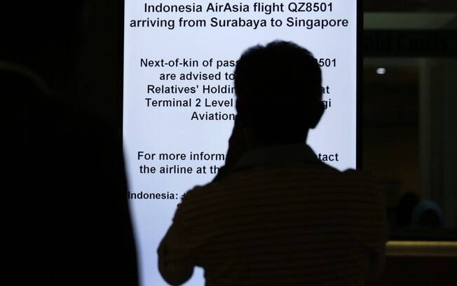 Familiar observa toten da AirAsia que informa sobre voo desaparecido. Foto: AP Photo/Wong Maye-E