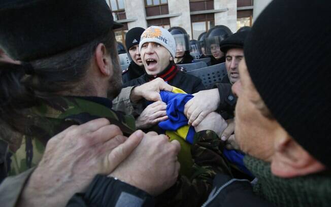 Manifestantes pró-Rússia protestam na cidade de  Donetsk, na Ucrânia, e arrancam bandeira nacional de poste (09/03/2014)