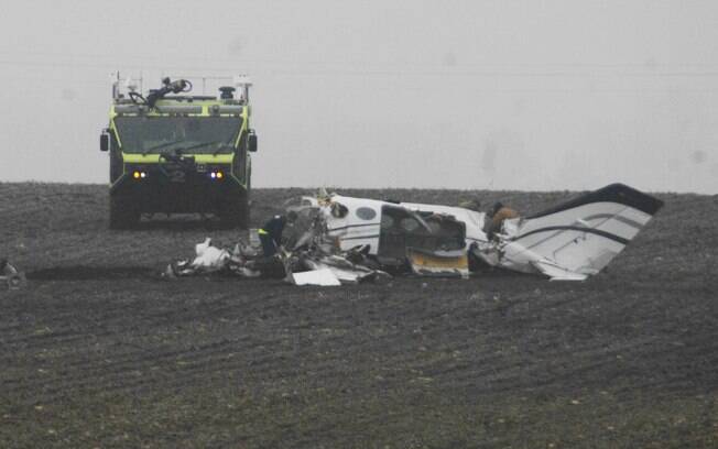 Os investigadores trabalham no local de um pequeno acidente de avião perto de Bloomington, EUA (7/04)