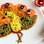 Pavão feito com molho de tomate – usado para desenhar o contorno do pavão-, lentilha, milho, cenoura, rabanete e azeitonas. Foto: Little Food Junction