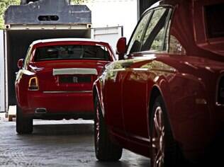 Fila de sedãs Rolls-Royce Phantom se forma. Os carros entram em conteiners para serem entregues ao bilionário que os comprou