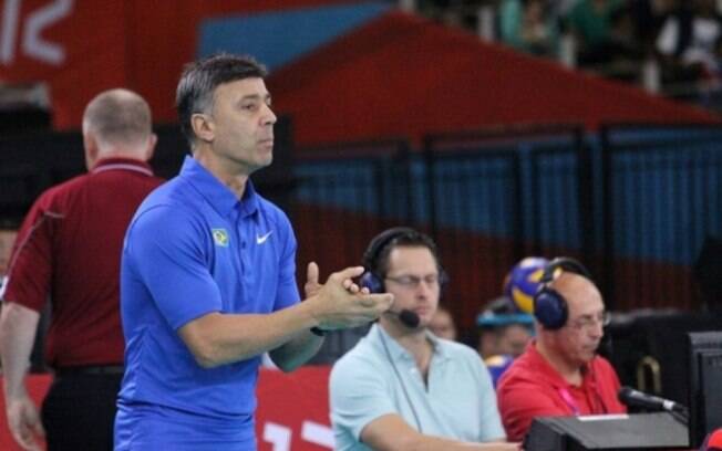 O técnico Fernando Guimarães orienta atletas da seleção brasileira de vôlei sentado