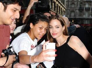 Angelina Jolie posa com fã na première de
