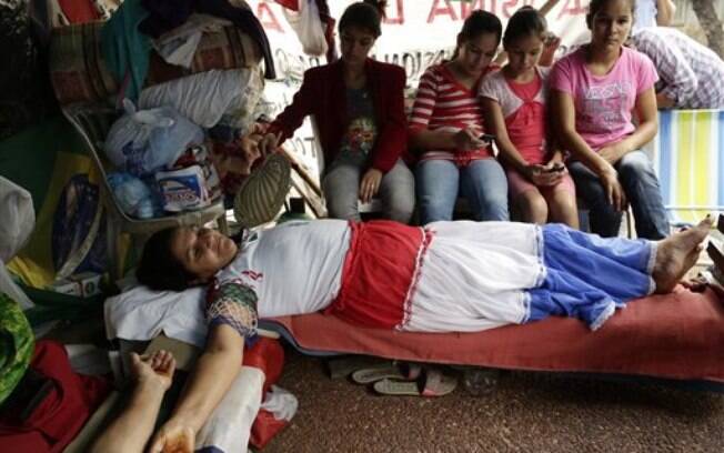 Mulher é crucificada em protesto em Assunção, no Paraguai. Foto: AP Photo