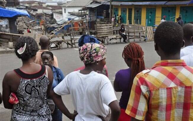 Residentes de Monrovia (Libéria) se aglomeram perto do centro de tratamento do ebola. Ruas foram fechadas afetando o retorno para casa dos moradores, por causa da quarena
