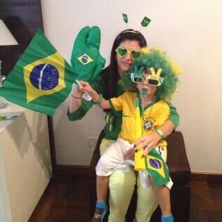 Ana Carolina e o filho com os acessórios que usarão durante os jogos do Brasil