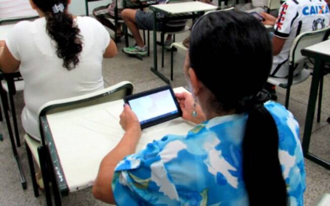 Jovens e adultos usam celular em sala de aula