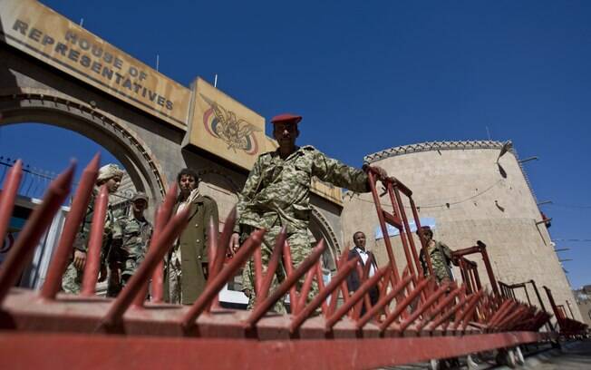Xiitas iemenitas vestindo uniformes do Exército montam guarda em frente ao Parlamento durante reunião em Sanaa, Iêmen (9/02)
