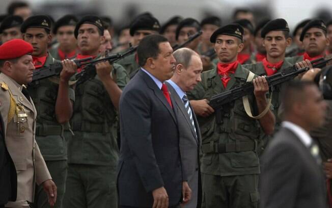 Chávez e Vladimir Putin passam por tropas durante cerimônia em Caracas em abril de 2010