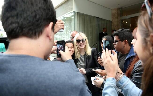 Dakota Fanning tira foto com fãs em porta de hotel, no Rio 