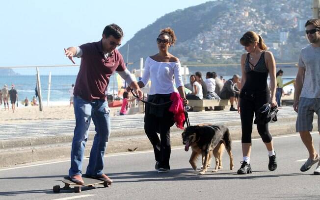 A atriz Sheron Menezzes optou por uma caminhada pela orla da praia de Ipanema, acompanhada de seu cachorro e de alguns amigos
