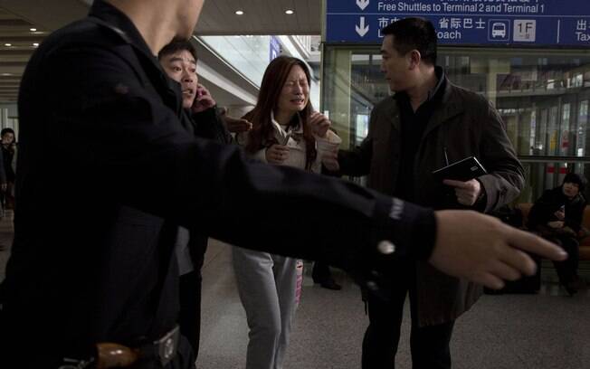 Parentes de passageiros buscam informações do voo MH370 da Malaysia Airlines que voava para Pequim (8/3). Foto: AP