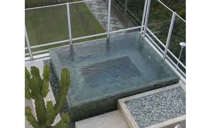 Gilberto Elkis assina o paisagismo desta piscina que combina elementos de banheira no topo da residência
