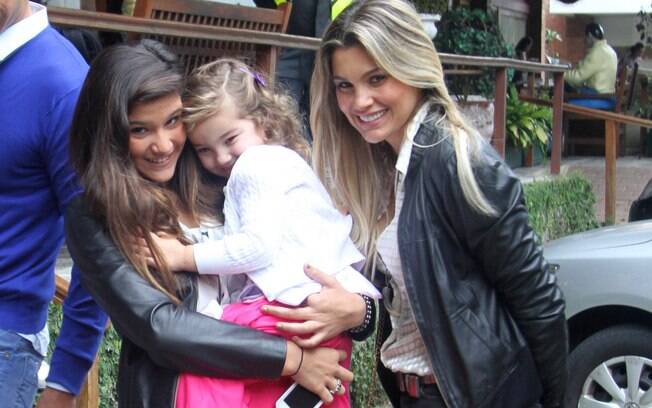 Giulia com a irmã, Olivia, no colo, ao lado da mãe, Flávia Alessandra