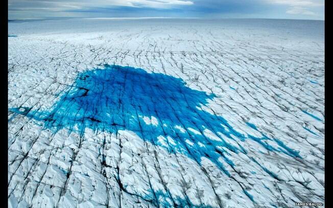 Este pequeno lago de água descongelada foi resultado de altas temperaturas que atingiram o manto de gelo da Groenlândia. A água escoa pelo gelo e desemboca no oceano. Foto: James Balog