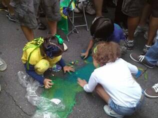 Crianças pintam cartaz em manifestação em São Paulo, no domingo (15)