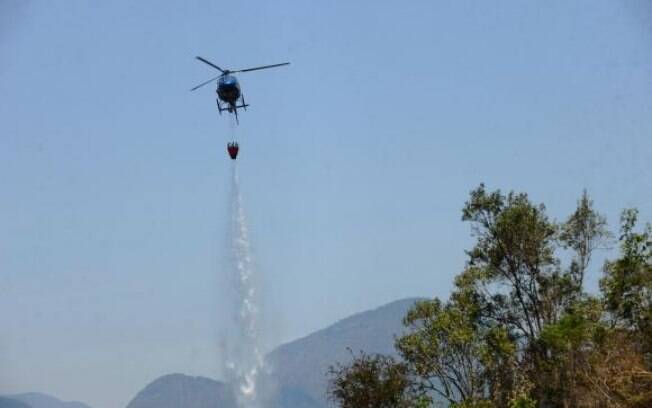 Helicóptero do Corpo de Bombeiros joga água sobre chamas na região serrana do Rio, em 2014