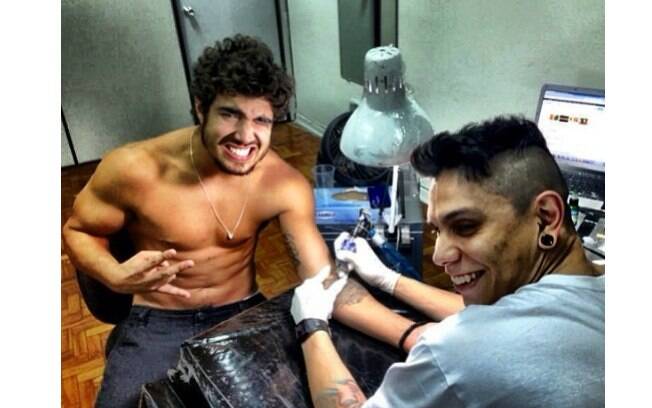 Caio Castro tira a camisa para retocar tatuagem no braço