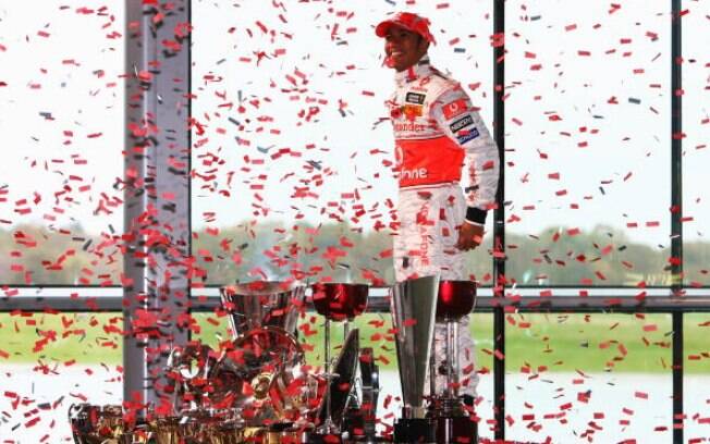 Lewis Hamilton comemora o título do Mundial de Pilotos de 2008 com os troféus conquistados durante a temporada