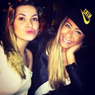 De boné e lentes de contato azuis, Rafaella Santos posa com amiga
