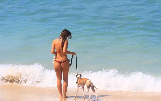 Sol e calor na capital fluminense: Banhista passeia com cachorro na praia de Ipanema, na zona sul
