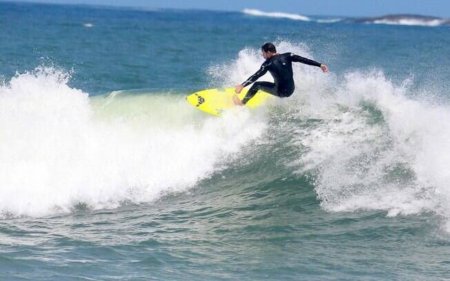 Cauã Reymond surfa na praia da Barra da Tijuca