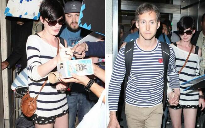 Acompanhada do marido, Anne Hathaway atende fãs no aeroporto de Los Angeles