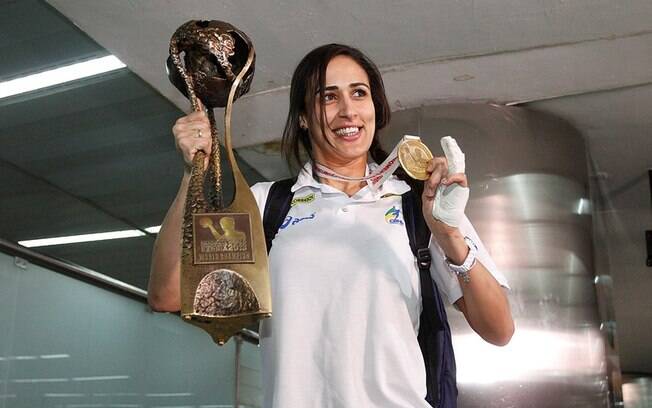 Com a mão esquerda machucada, Dara exibe o troféu de campeão mundial da seleção brasileira feminina de handebol