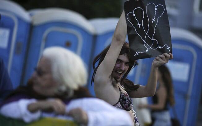 Manifestante segura um desenho feito com o rosário na praia de Copacabana, onde o papa Francisco celebrou a missa na sexta-feira 27 de julho