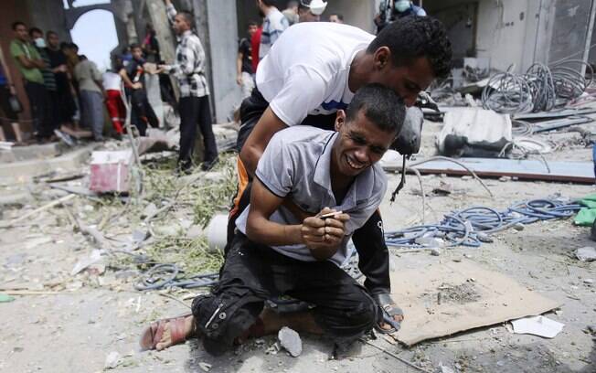 Palestino chora após o corpo de sua mãe ser retirado de escombros de casa destruída por ataque aéreo israelense, segundo testemunhas, em Rafah, Gaza (4/08)