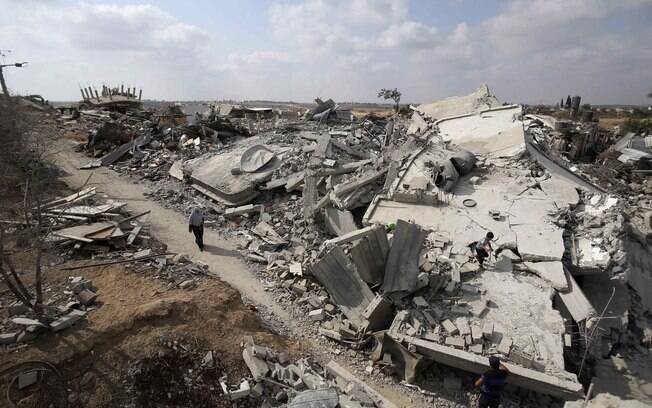 Palestina caminha pelas ruínas de casas que testemunhas disseram ter sido destruídas por ofensiva israelense na vila de Jöhr El-Deek, em Gaza (17/08)