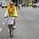 Em Brasília, uma mulher pedala sua bicicleta de camiseta do Brasil e um cartaz com os dizeres 