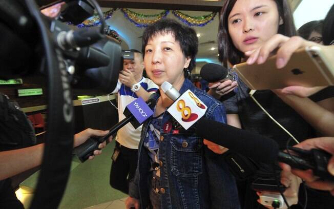 Jornalistas tentam entrevistar familiares dos passageiros do voo 8501 da AirAsia no aeroporto de Cingapura. Foto: AP Photo/Xinhua, Then Chih Wey
