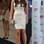 A modelo Tamara Ecclestone escolheu vestido curto branco e prateado. As sandálias Christian Louboutin prateadas, as pulseiras e a clutch deixam o look mais poderoso. Foto: Getty Images