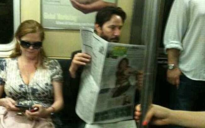 Keane Reeves aproveita a viagem de metrô para ler o jornal