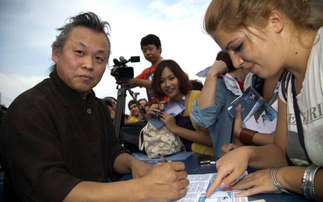 O cineasta sul-coreano Kim Ki-duk, que participa da competição com 'Pietà', distribui autógrafos