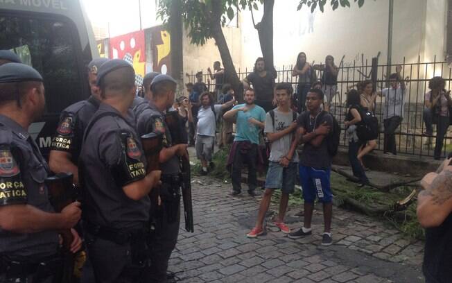 Policiais militares observam estudantes em manifestação em frente à escola estadual Fernão Dias