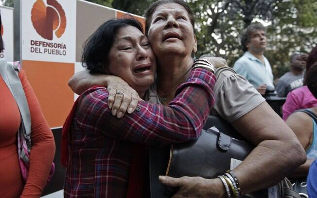 Mulheres choram e se abraçam após o anúncio da morte de Chávez pelo vice Nicolas Maduro (05/03)