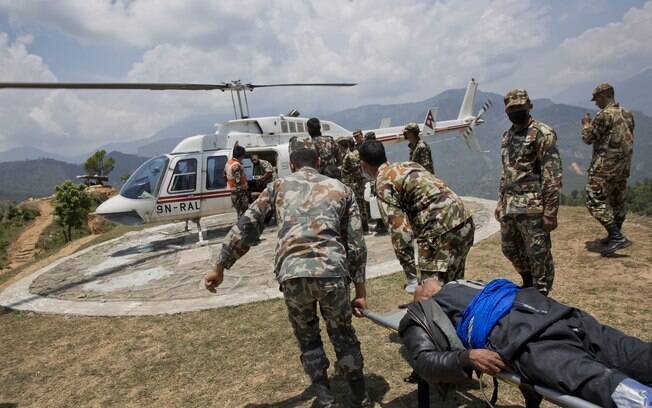Helicóptero aguarda para evacuar um dos feridos no terremoto que atingiu a região de  Chautara, no Nepal (13.5.2015)