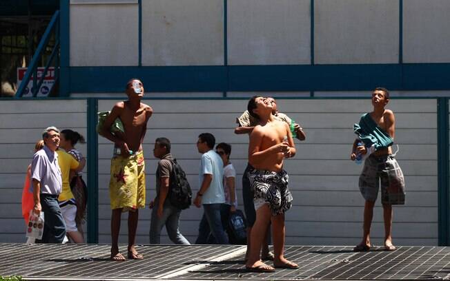 Garotos se refrescam do forte calor em cima da saída de ar do metrô, na Avenida Paulista, em São Paulo (SP), na tarde deste sábado (01)