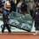 Funcionários levam banco que Djokovic quebrou com a sua raquete. Foto: AP