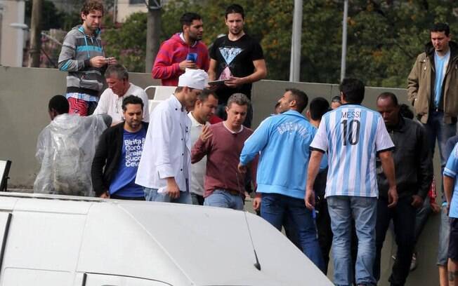 Ashton Kutcher e Luciano Huck em meio aos argentinos acampados no Rio de Janeiro