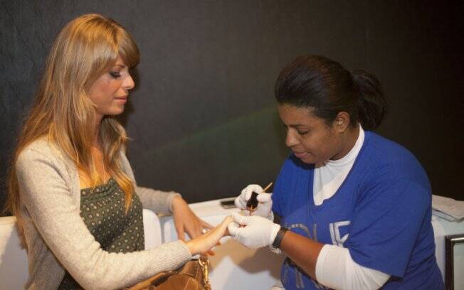 Caroline pinta as unhas e se prepara para acompanhar o desfile